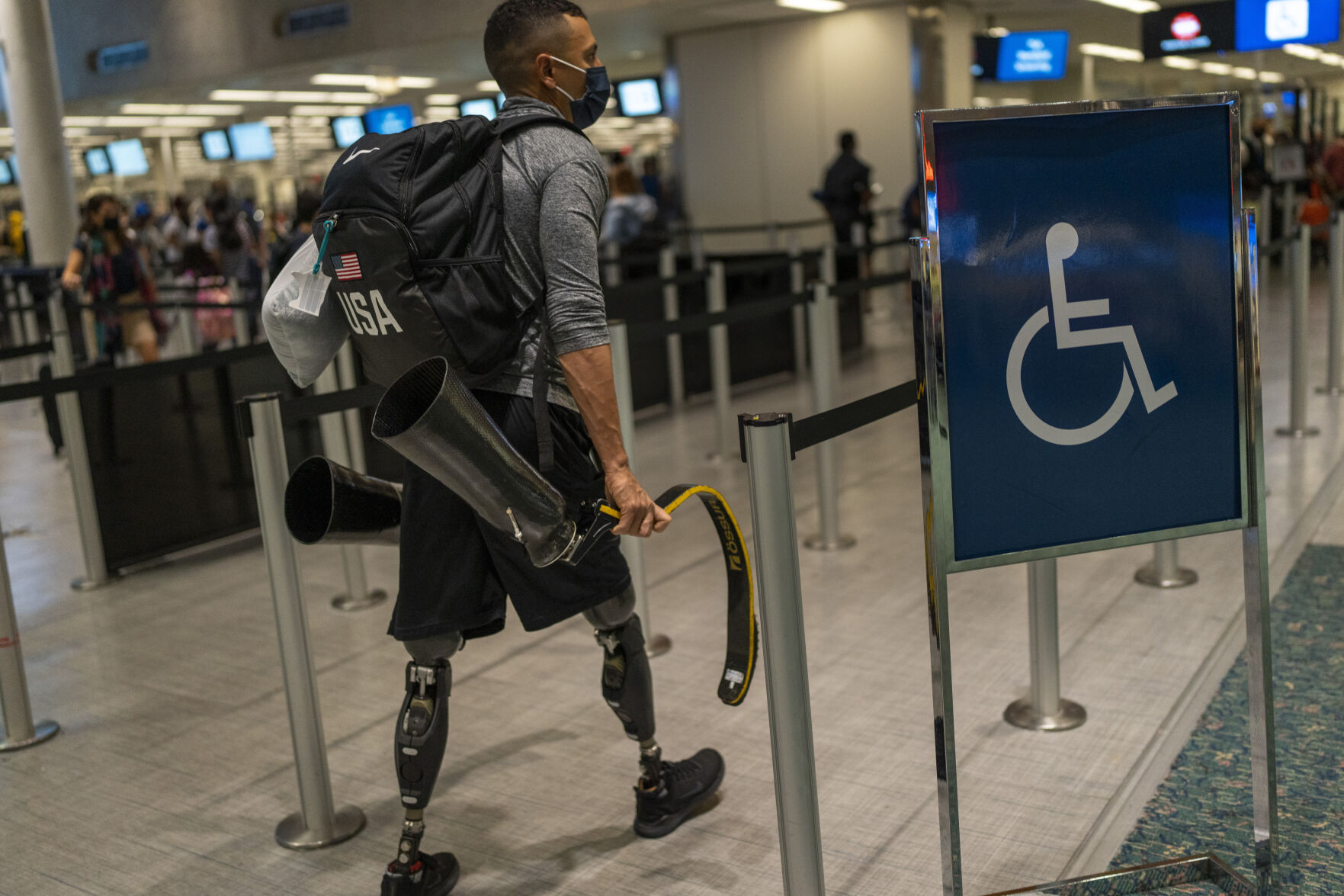 <p>Luis Puertas carries his prosthetic blades as he arrives at the airport in Orlando, Fla., on Monday, Aug. 9, 2021, before flying to Tokyo to take part in the Paralympics. Puertas, 34, lost both his legs in September 2006 as he patrolled a crowded Baghdad neighborhood. His legs were severed when a massive IED blasted through his armored vehicle. (AP Photo/Emilio Morenatti)</p>