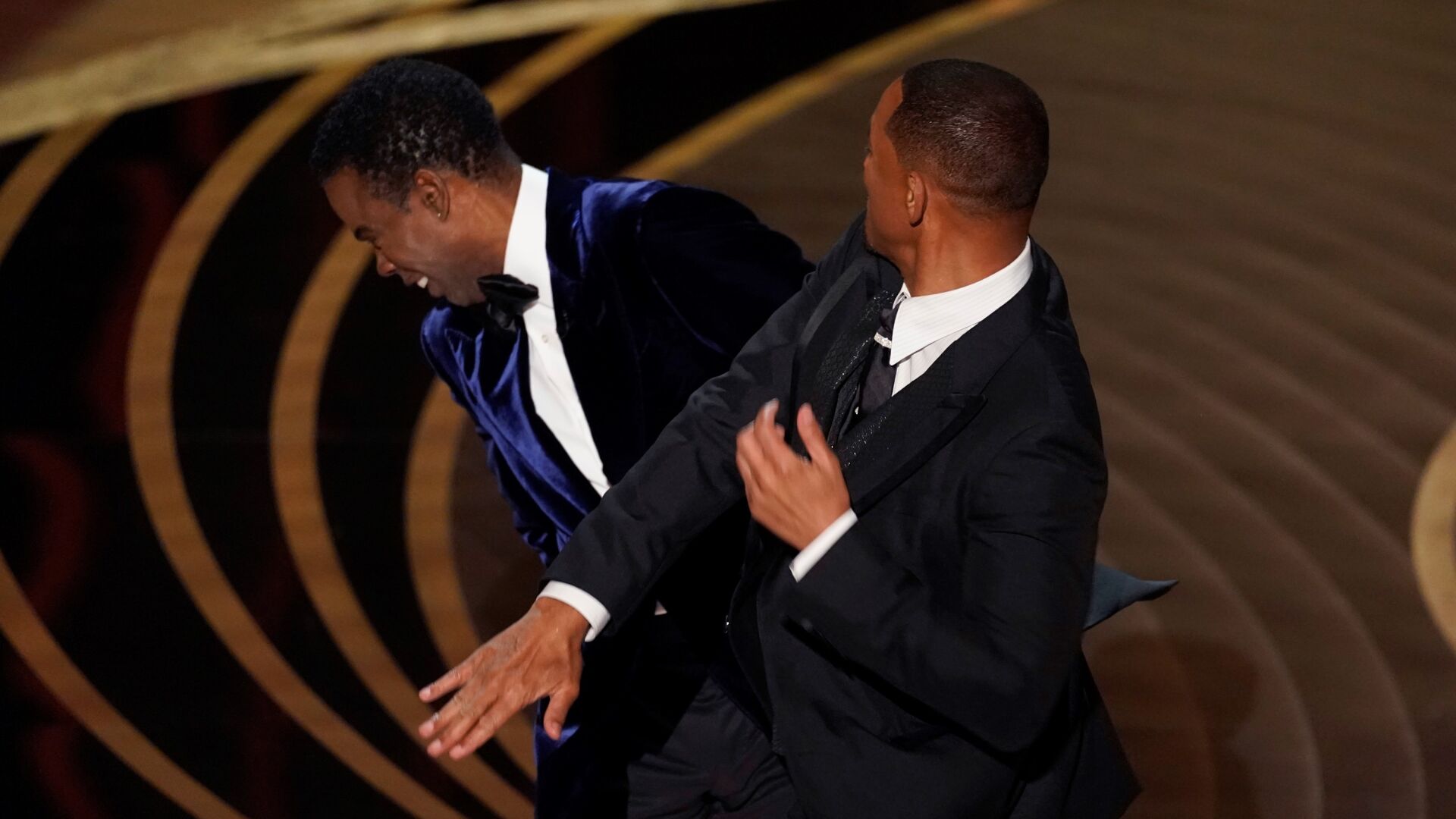 <p>FILE - Will Smith, right, hits presenter Chris Rock on stage at the Oscars in Los Angeles on March 27, 2022, after Rock made a joke about his wife. </p>