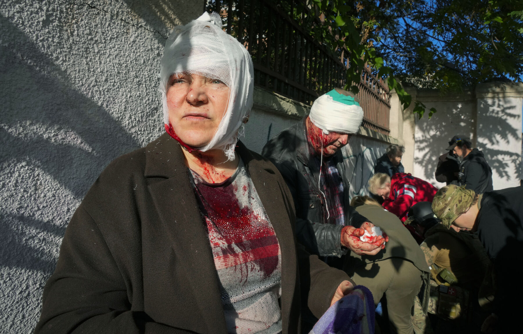 <p>People receive medical treatment at the scene of Russian shelling, in Kyiv, Ukraine, Monday, Oct. 10, 2022. Two explosions rocked Kyiv early Monday following months of relative calm in the Ukrainian capital. </p>