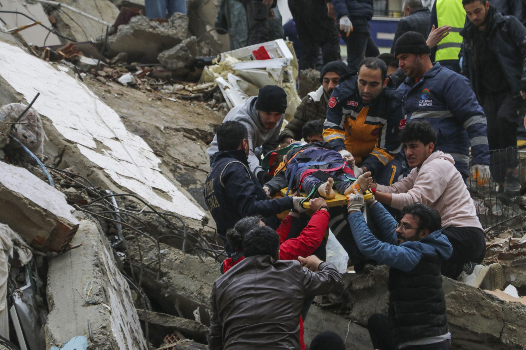 <p>People and emergency teams rescue a person on a stretcher from a collapsed building in Adana, Turkey, Monday, Feb. 6, 2023. A powerful quake has knocked down multiple buildings in southeast Turkey and Syria and many casualties are feared. </p>