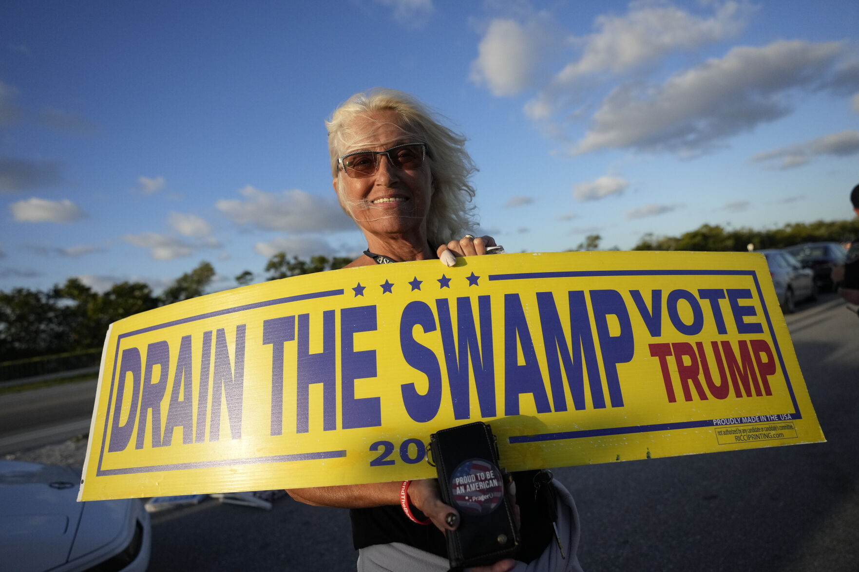 <p>Liz DePiro, 67, of Deerfield Beach, Fla., holds a sign as she demonstrates to show support for former President Donald Trump a day after he was indicted by a Manhattan grand jury Friday near Trump's Mar-a-Lago estate in Palm Beach, Fla. </p>