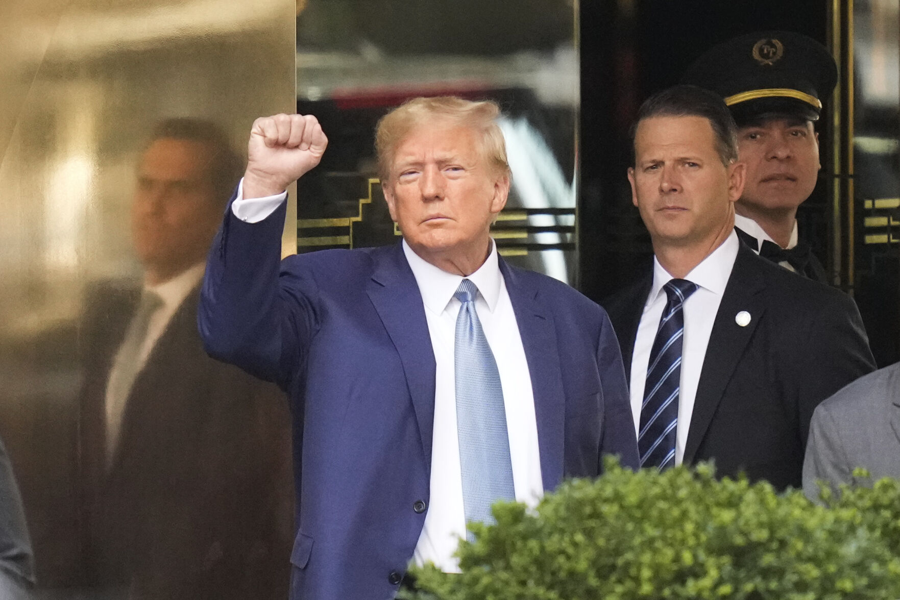 <p>Former President Donald Trump, left, gestures as he leaves Trump Tower on April 13 in New York.</p>