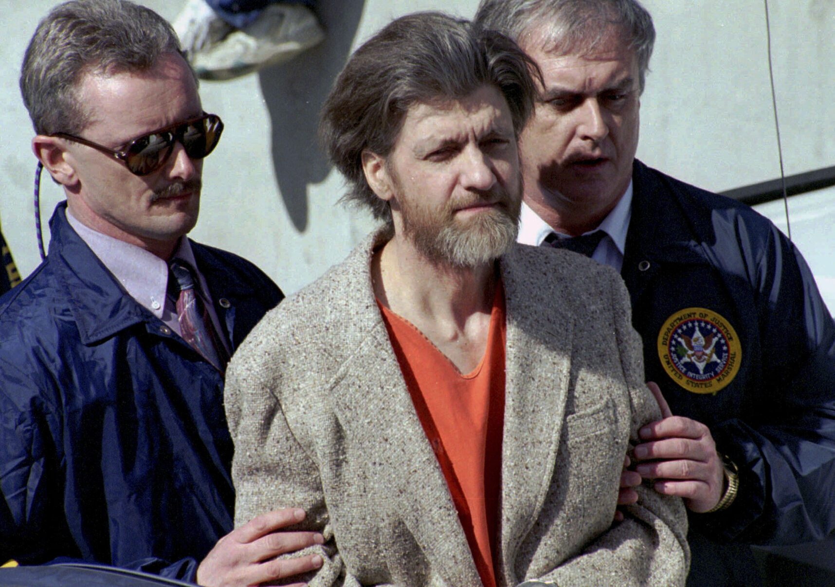 <p>Theodore "Ted" Kaczynski is flanked by federal agents as he is led to a car from the federal courthouse April 4, 1996, in Helena, Mont.</p>
