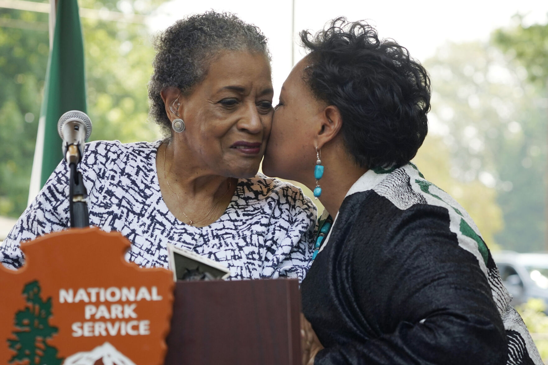 <p>Myrlie Evers, left, is kissed by her daughter Reena Evers-Everette prior to the unveiling of the new park sign for the Medgar and Myrlie Evers Home National Monument on Thursday in Jackson, Miss.</p>
