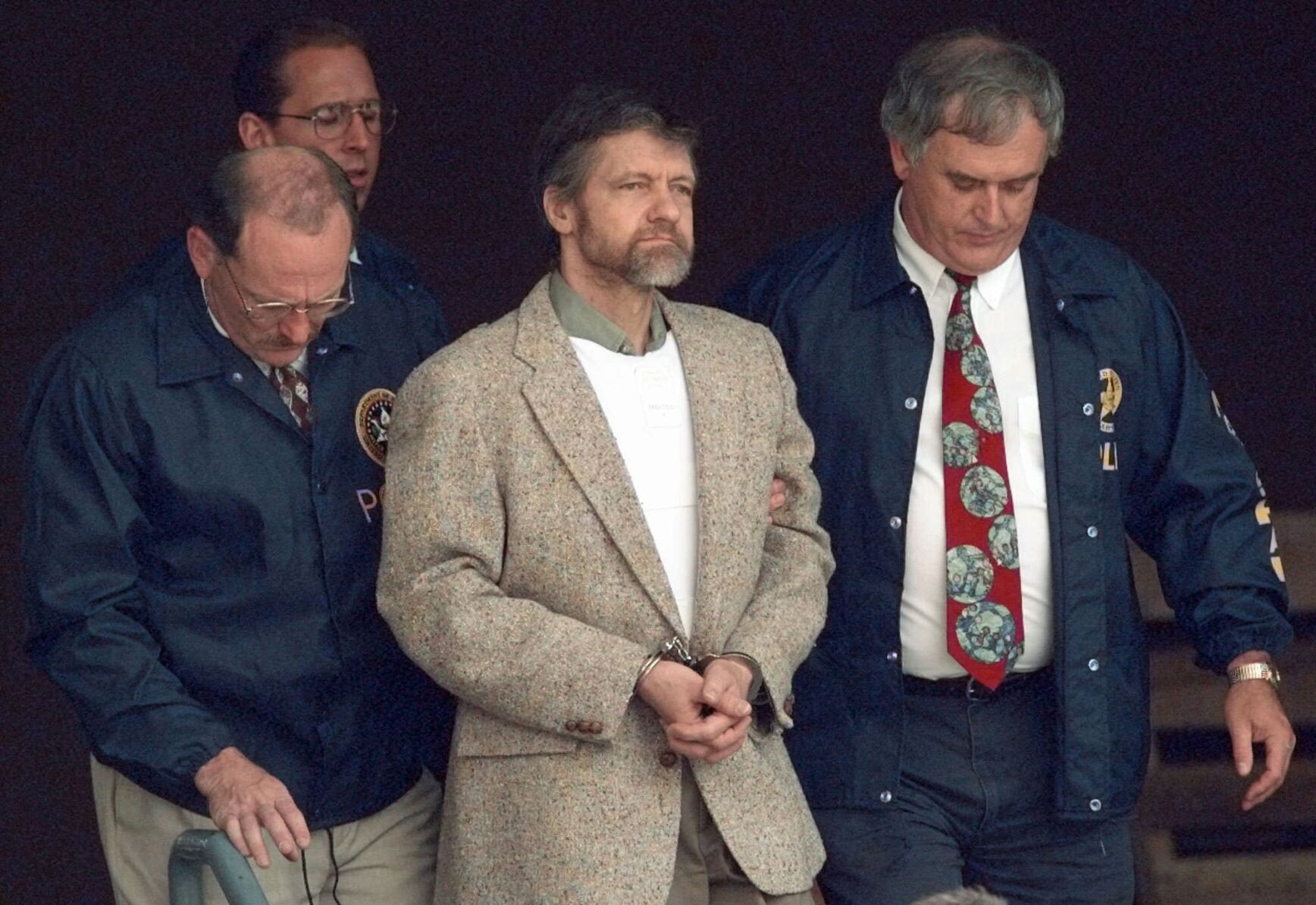 <p>Theodore Kaczynski looks around as U.S. Marshals prepare to take him down the steps at the federal courthouse to a waiting vehicle on June 21, 1996, in Helena, Mont. </p>