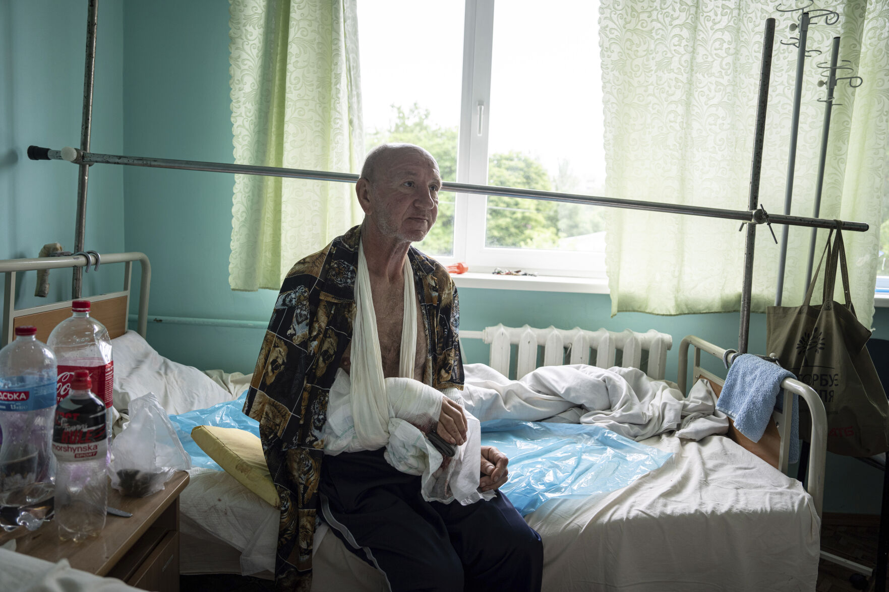 <p>Vitalii Shpalin, 60, sits on a bed in a hospital Monday in Kherson region, Ukraine, after he was shot on Sunday while fleeing on a boat from a flooded village on the left bank of the Dnipro river in Ukraine. </p>