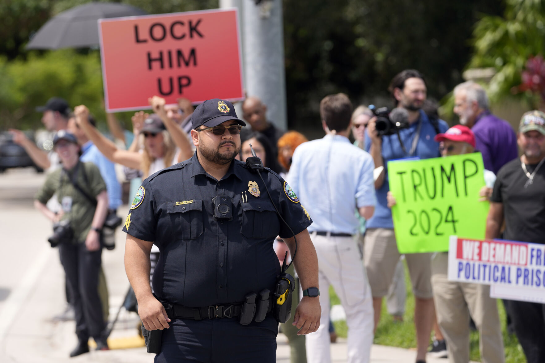<p>A police officer helps with traffic control as protesters and supporters wait for Trump to arrive at Trump National Doral resort Monday in Doral, Fla.</p>
