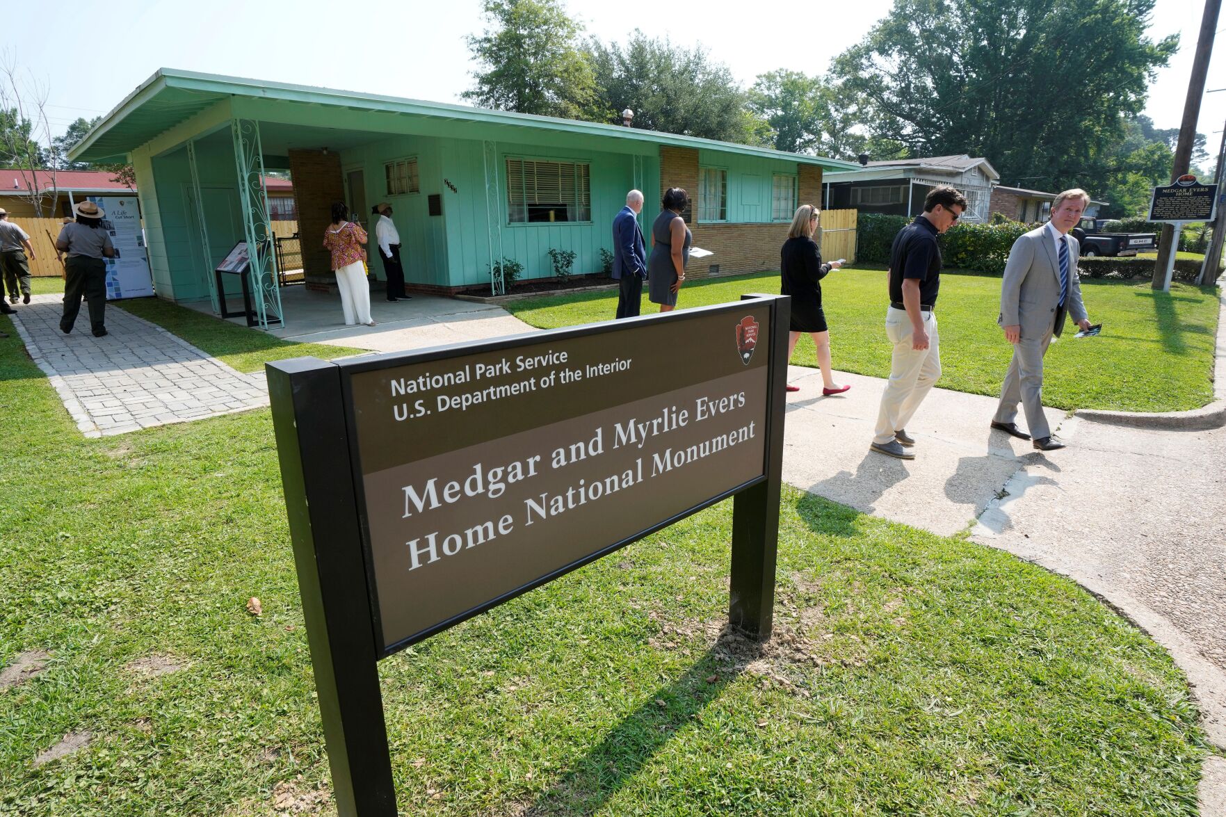 <p>Invited guests exit the Medgar and Myrlie Evers Home National Monument on Thursday in Jackson, Miss. The new sign is part of the Medgar and Myrlie Evers Home National Monument, which includes the development of an outdoor education space and garden area next to the home site.</p>