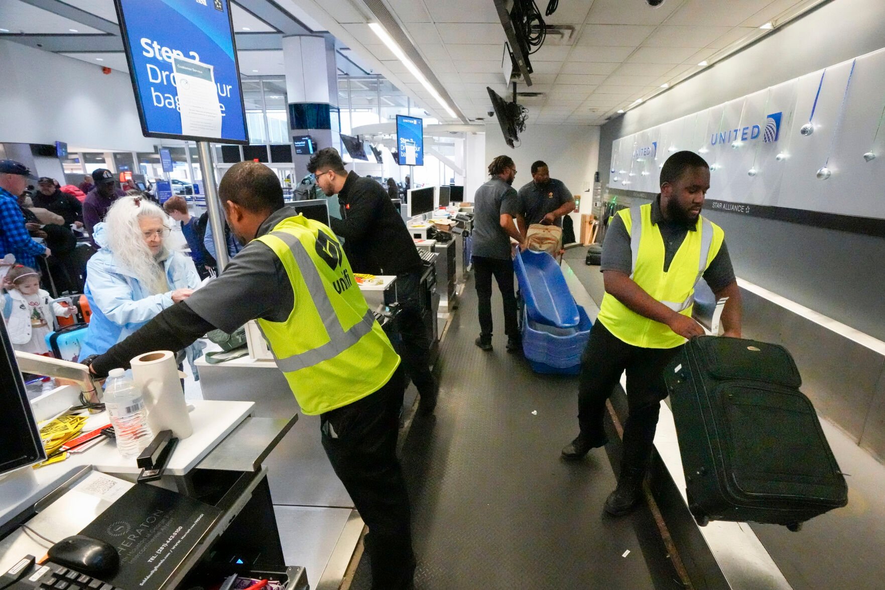 <p>File - Agents check-in passengers and their baggage at George Bush Intercontinental Airport on Dec. 21, 2023, in Houston. On Friday, the U.S. government issues its December jobs report. (Brett Coomer/Houston Chronicle via AP, File)</p>