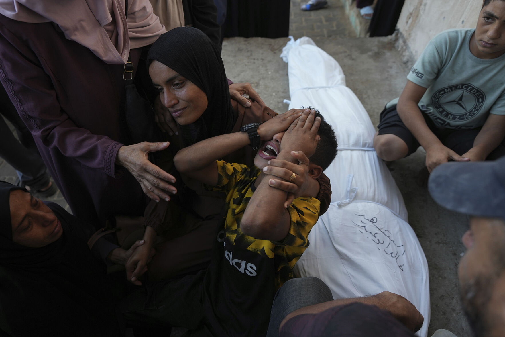 <p>Mourners attend the funeral Wednesday for Palestinians killed in the Israeli bombardment of the Gaza Strip outside the hospital morgue in Deir al-Balah.</p>