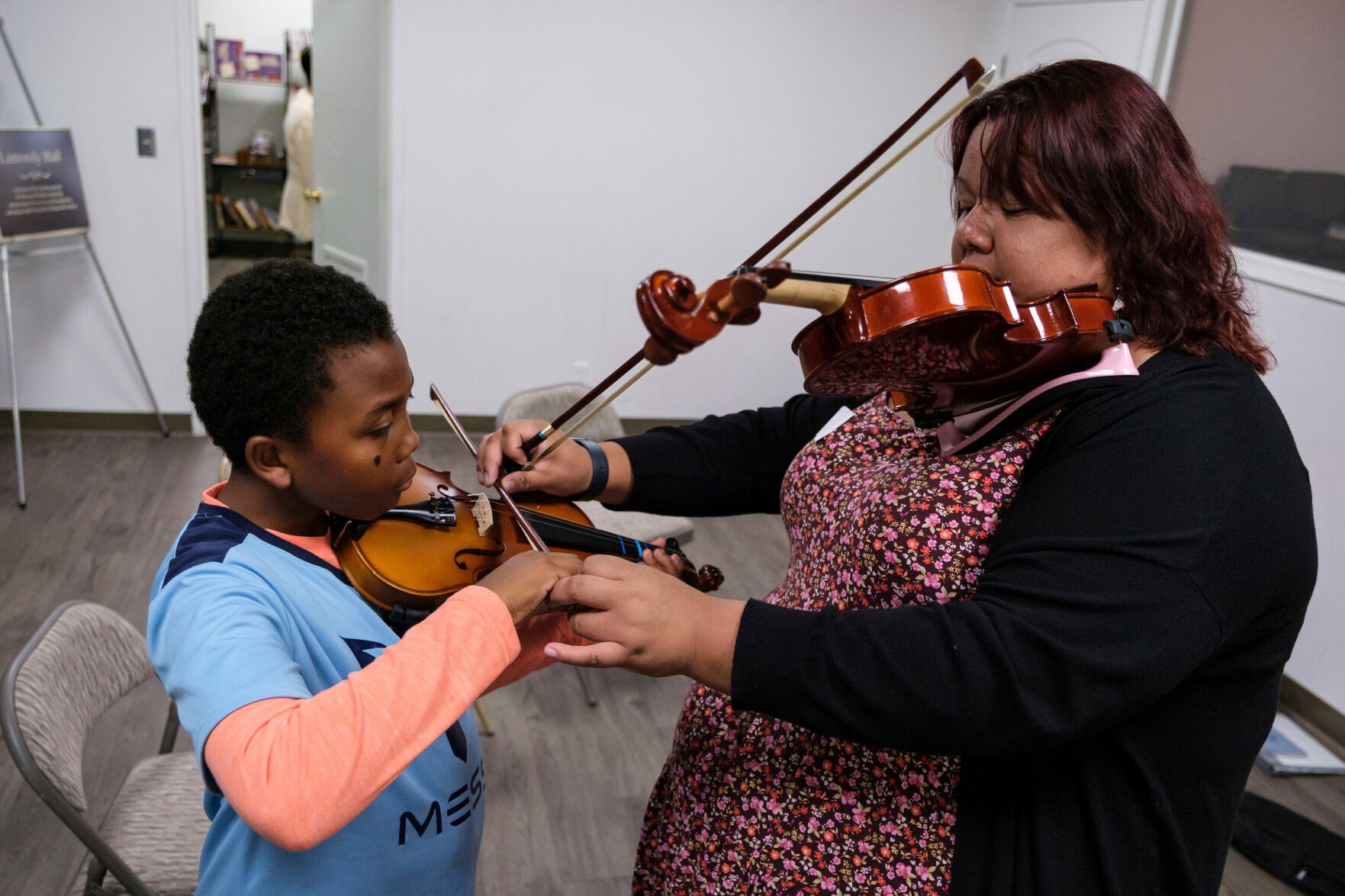 <p>Johnathan Nealy, left, learns how to play the violin as part of an initiative that aims to promote equity in classical music at New Hope Presbyterian Church on Oct. 16 in Anaheim, Calif.</p>