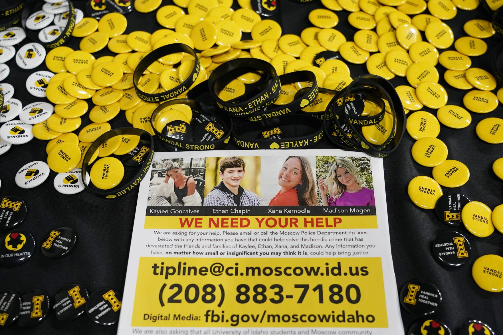 <p>A flyer seeking information about the killings of four University of Idaho students who were found dead is displayed on a table along with buttons and bracelets on Nov. 30, 2022, during a vigil in memory of the victims in Moscow, Idaho.</p>