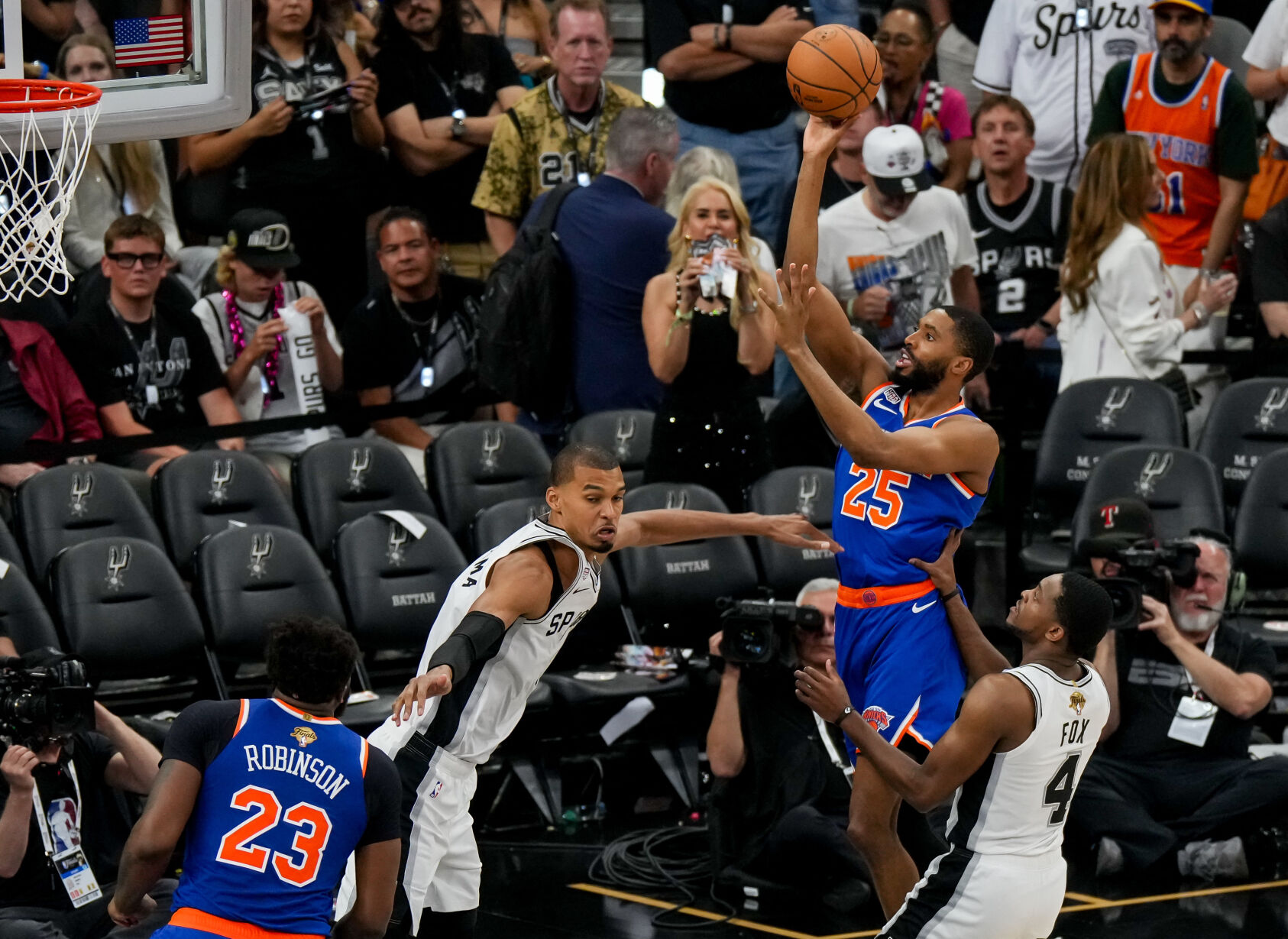 <p>New York Knicks guard Mikal Bridges shoots over San Antonio Spurs forward Victor Wembanyama during the second half in Game 5 of the NBA Finals on Saturday at Frost Bank Center in San Antonio.</p>