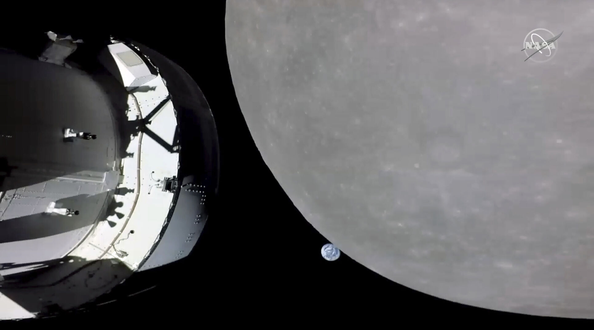 <p>This screengrab from NASA TV shows NASA's Orion capsule, left, nearing the moon, right, Monday, Nov. 21, 2022. At center is earth. </p>
