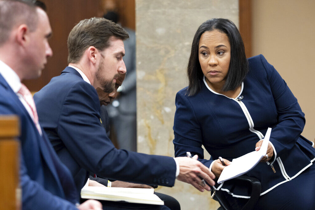 <p>FILE - Fulton County District Attorney Fani Willis, right, talks with a member of her team during proceedings to seat a special purpose grand jury in Fulton County, Georgia, on May 2, 2022, to look into the actions of former President Donald Trump and his supporters who tried to overturn the results of the 2020 election. </p>