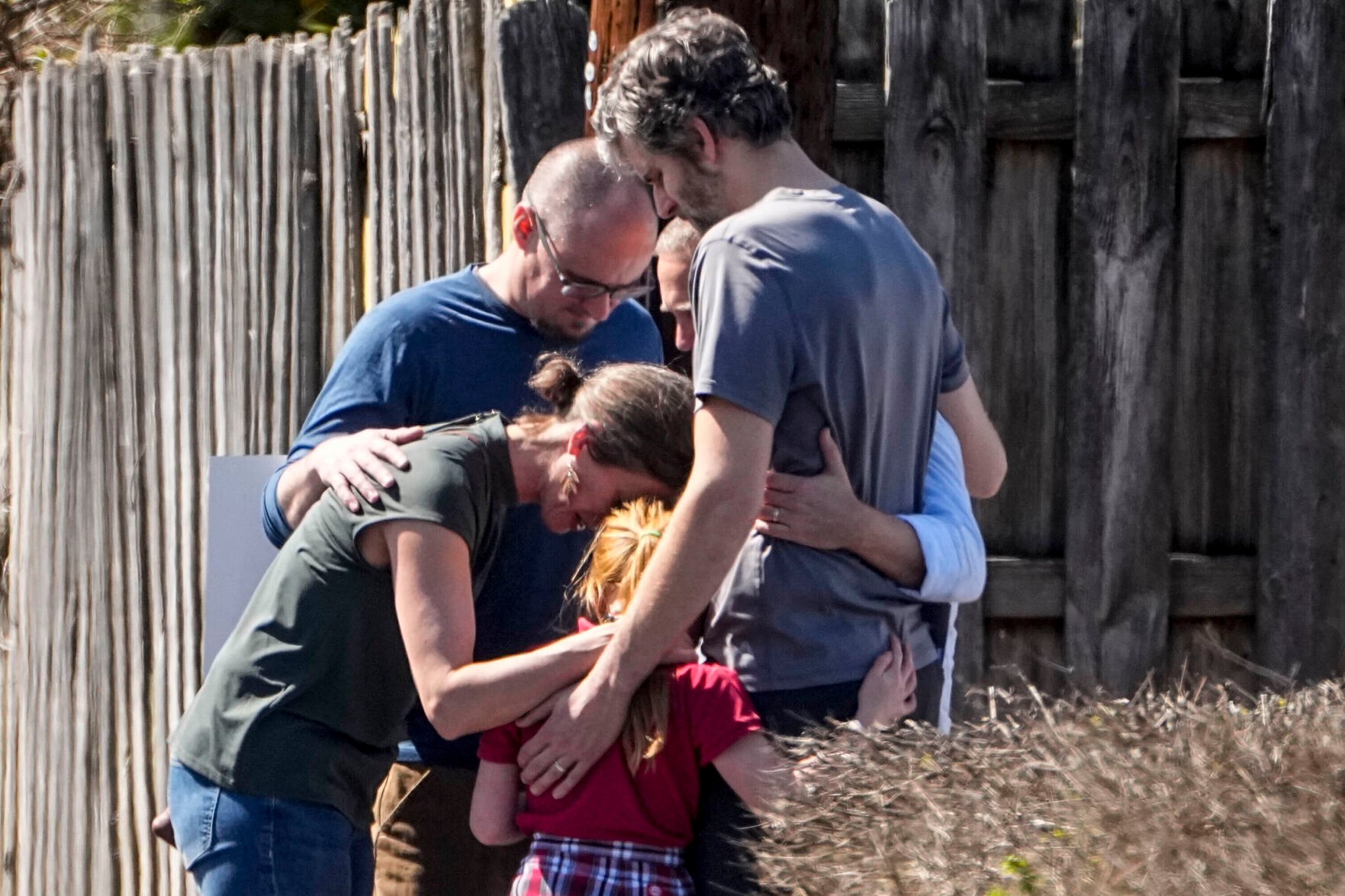 <p>A group prays with a child outside the reunification center at the Woodmont Baptist church after a school shooting, Monday, March 27, 2023, in Nashville, Tenn. (AP Photo/John Bazemore)</p>