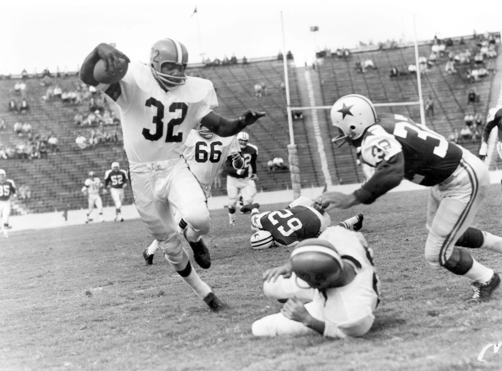 <p>FILE - In this October 1960 file photo, Cleveland Browns fullback Jim Brown (32) runs with a reception as Dallas Cowboys' Tom Franckhauser (32) defends and Don Healy falls to the turf during an NFL football game in Dallas. </p>