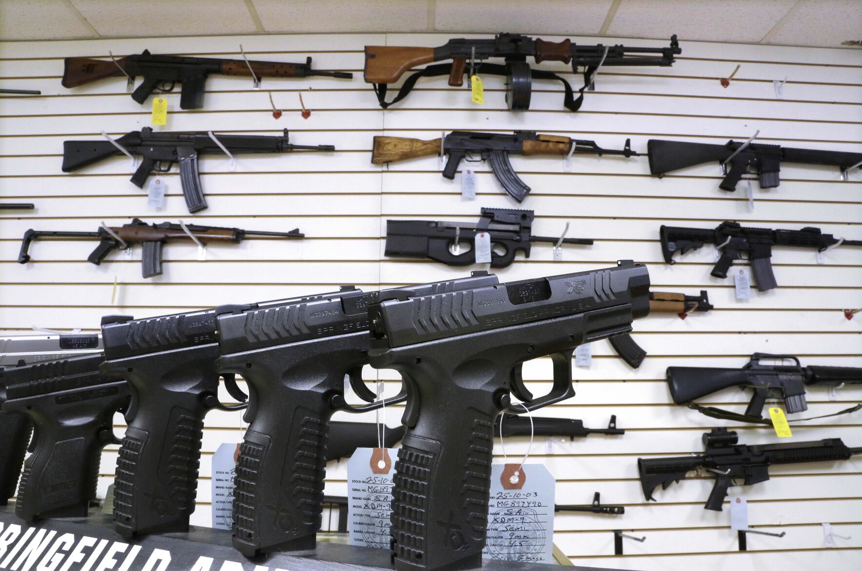 <p>FILE - Assault weapons and hand guns are seen for sale at Capitol City Arms Supply on Jan. 16, 2013, in Springfield, Ill. The Illinois Supreme Court will issue an opinion on the state's ban on the sale or possession of semi-automatic weapons of the type used in the 2022 Independence Day shooting in the Chicago suburb of Highland Park that killed seven and dozens of other mass shootings nationally. Rep. Dan Caulkins, a Decatur Republican, and other gun owners of Macon County filed the lawsuit contending the law not only violates the Second Amendment but equal protection of the laws because it exempts police and military from the ban. (AP Photo/Seth Perlman, File)</p>