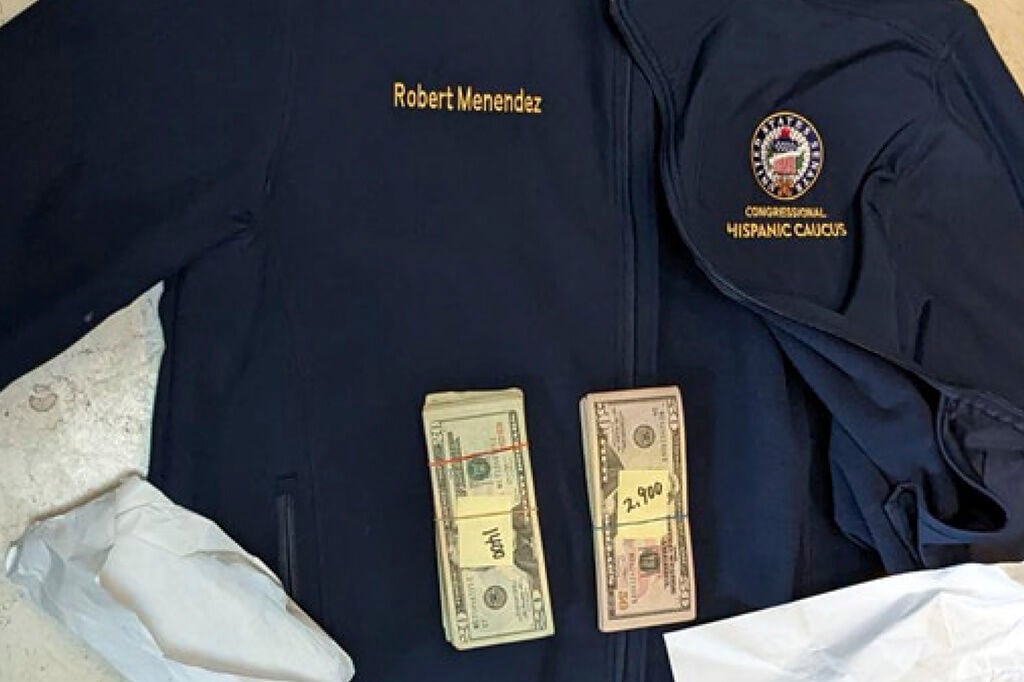<p>This photo, which was included in an indictment of U.S. Sen. Bob Menendez (D-N.J.), shows a jacket bearing Menendez's name, along with cash from envelops found inside the Jacket during a search by federal agents of the senator's home in Harrison, N.J., in 2022. </p>