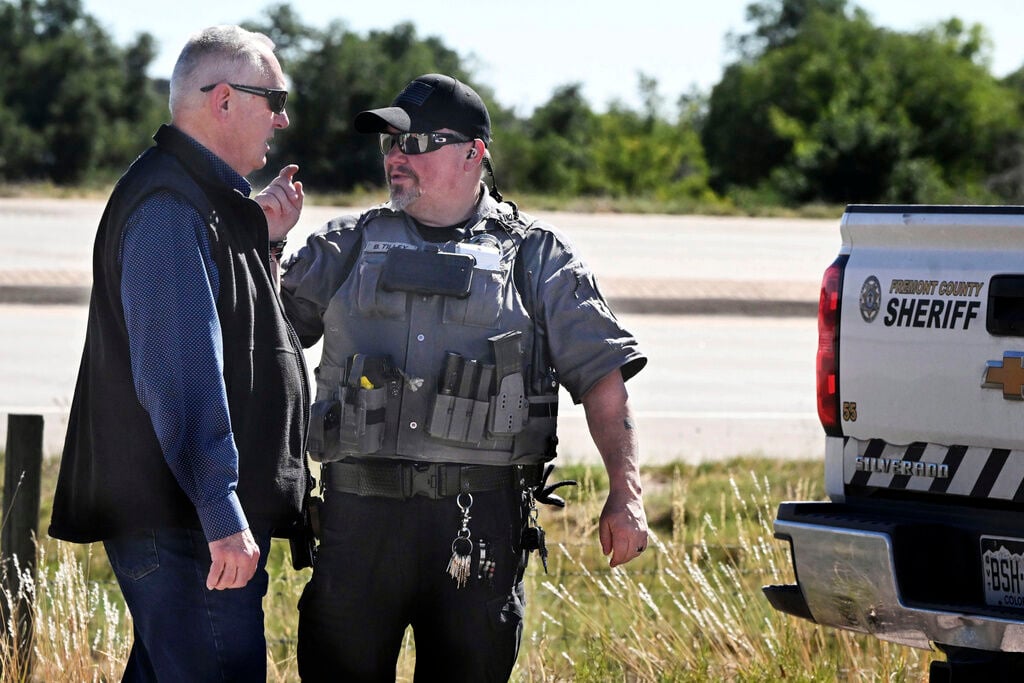 <p>Fremont County Sheriff Allen Cooper, left, talks a deputy at the road leading to the Return to Nature Funeral Home in Penrose, Colo. Thursday, Oct. 5, 2023. </p>
