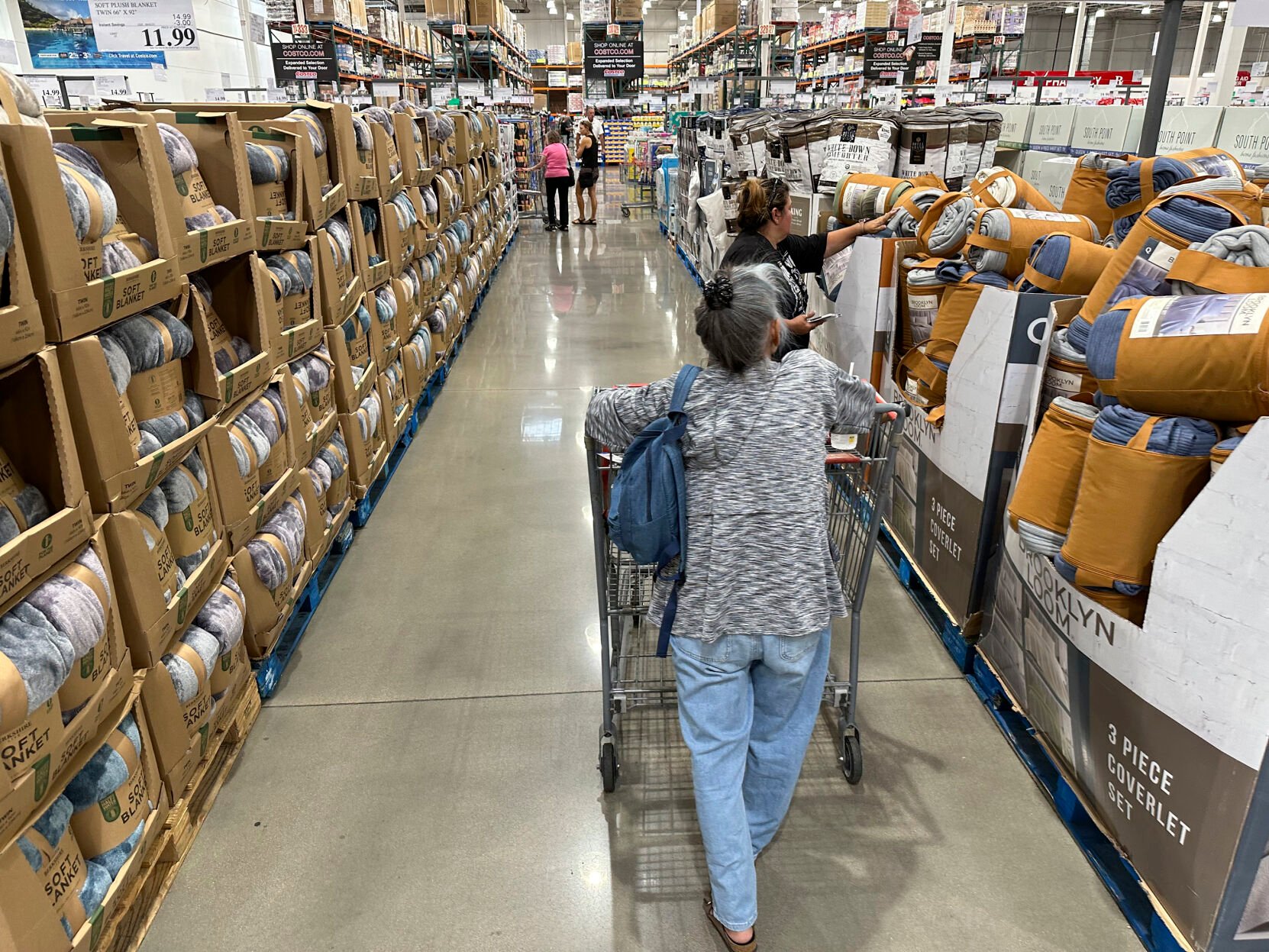 <p>File - Shoppers look over blankets on sale in a Costco warehouse on Aug. 24, 2023, in Sheridan, Colo. On Thursday, the Commerce Department issues its first of three estimates of how the U.S. economy performed in the third quarter of 2023. (AP Photo/David Zalubowski, File)</p>