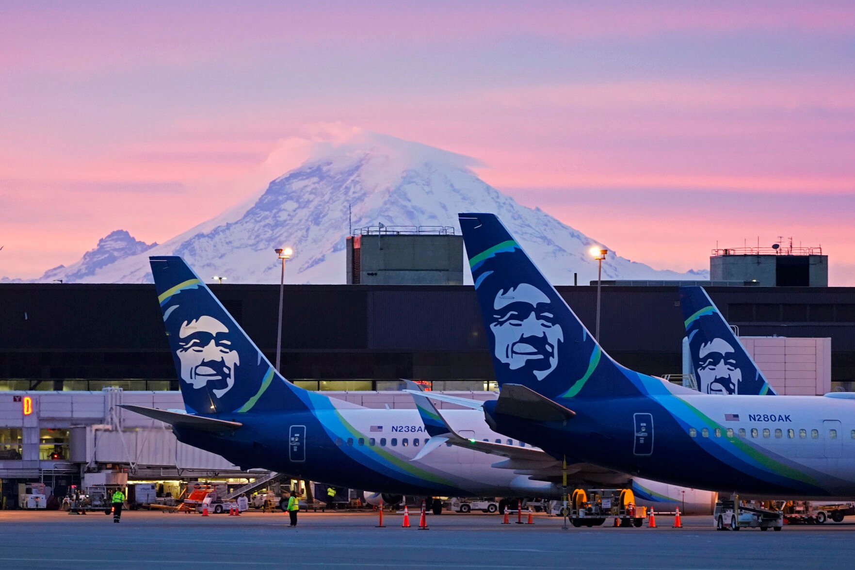 <p>Alaska Airlines planes are shown parked at gates with Mount Rainier in the background at sunrise March 1, 2021, at Seattle-Tacoma International Airport in Seattle. </p>