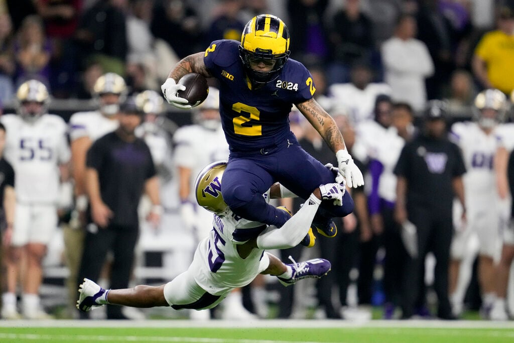<p>Michigan running back Blake Corum is tackled by Washington cornerback Elijah Jackson during the second half of the national championship NCAA College Football Playoff game Monday, Jan. 8, 2024, in Houston. (AP Photo/Godofredo A. Vasquez)</p>
