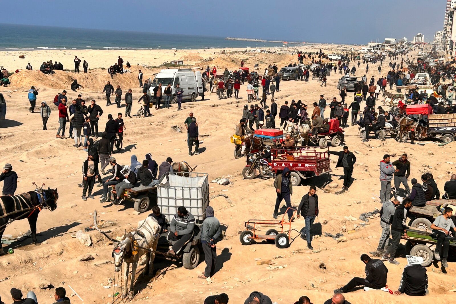 <p>Palestinians wait for humanitarian aid on a beachfront Sunday in Gaza City, Gaza Strip.</p>