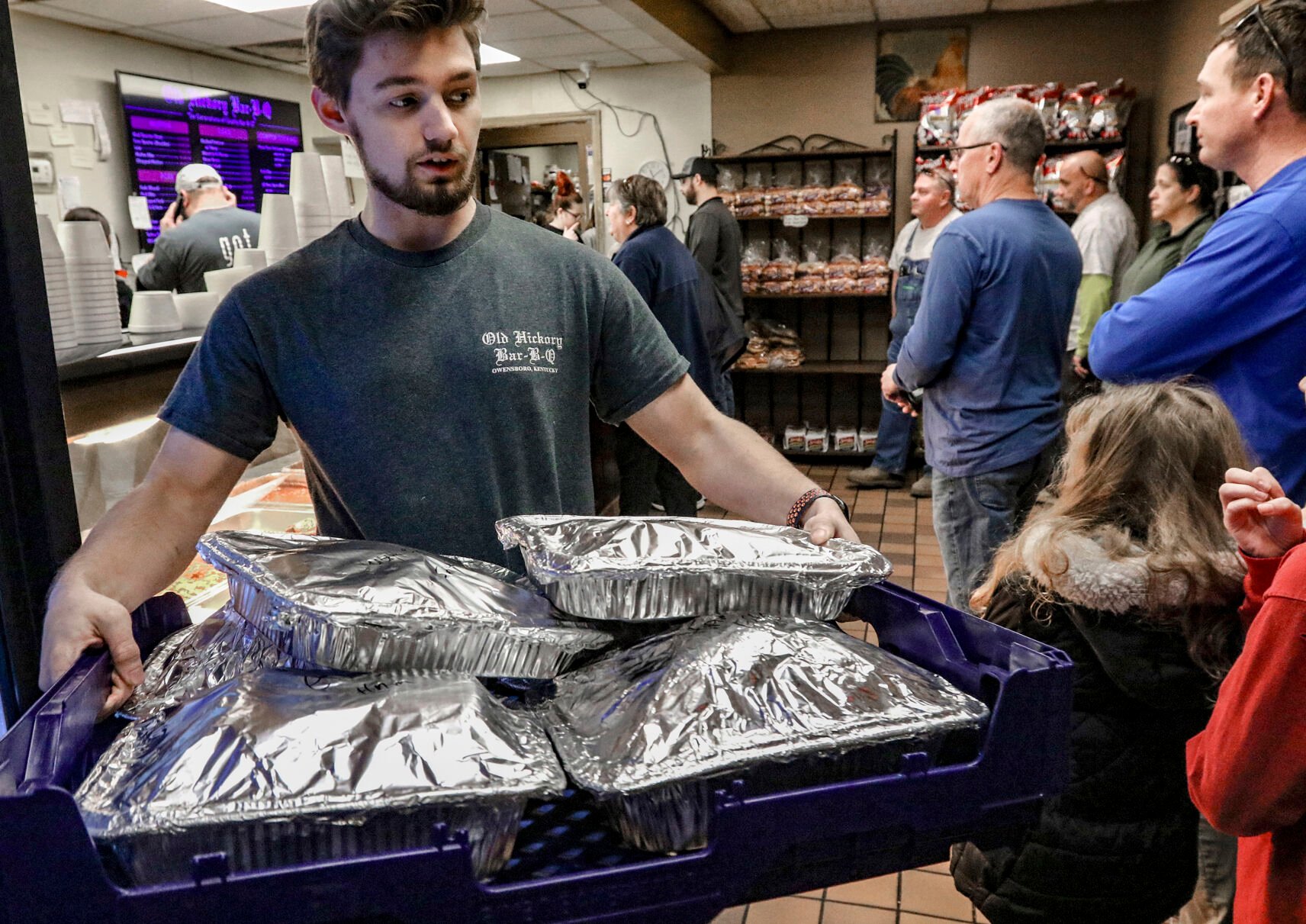 <p>File - Old Hickory Bar-B-Que employee Tyler Reynolds carries a tray of sliced hams of the the restaurant on Dec. 22, 2023, in Owensboro, Ky. On Friday, Feb. 2, 2024, the U.S. government issues its January jobs report.</p>