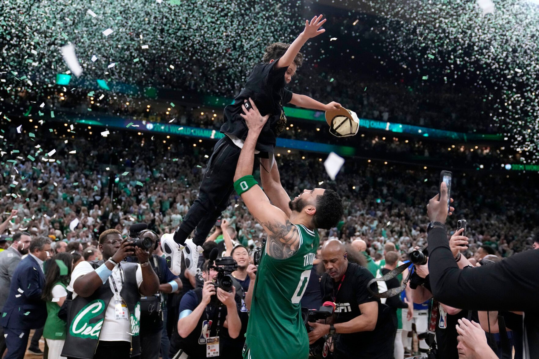 <p>Boston forward Jayson Tatum lifts his son Deuce as he celebrates after the Celtics win the NBA championship with a Game 5 victory over Dallas Mavericks on Monday in Boston.</p>