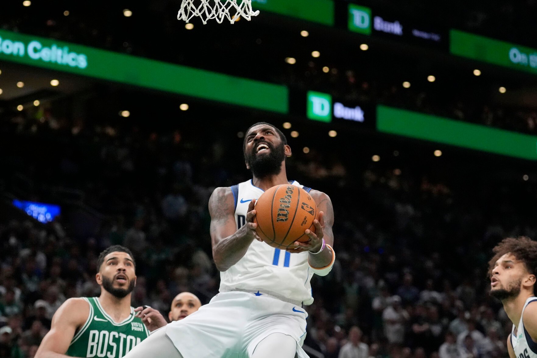 <p>Dallas Mavericks guard Kyrie Irving, center, drives toward the basket in front of Boston Celtics forward Jayson Tatum, left, during Game 5 of the NBA Finals on Monday in Boston.</p>