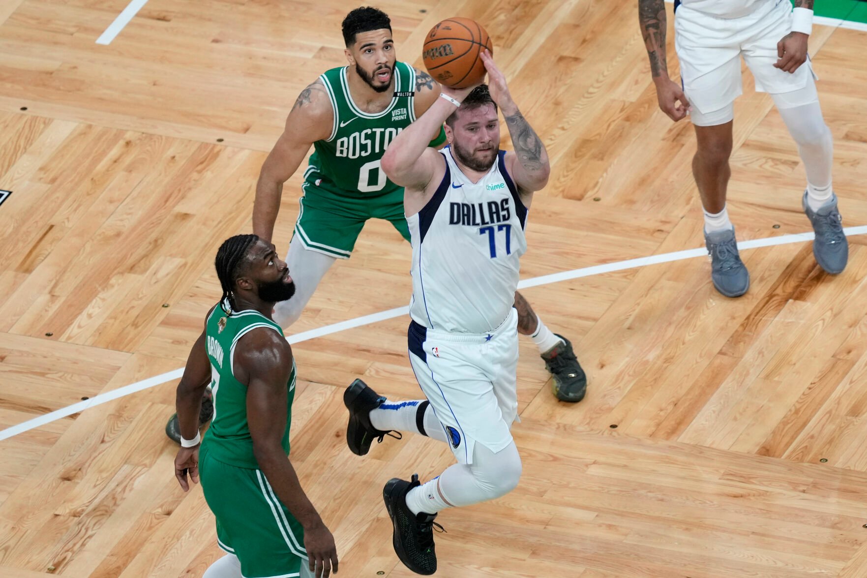 <p>Dallas Mavericks guard Luka Doncic goes up for a shot in front of Boston Celtics guard Jaylen Brown, left, and forward Jayson Tatum during Game 5 of the NBA Finals on Monday in Boston.</p>