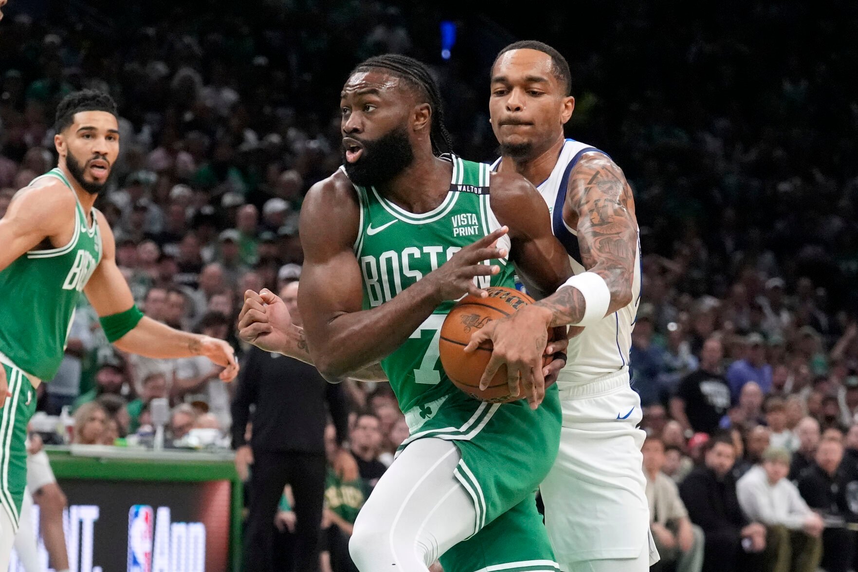 <p>Boston Celtics guard Jaylen Brown, center, drives toward the basket as Dallas Mavericks forward P.J. Washington defends during Game 5 of the NBA Finals on Monday in Boston.</p>