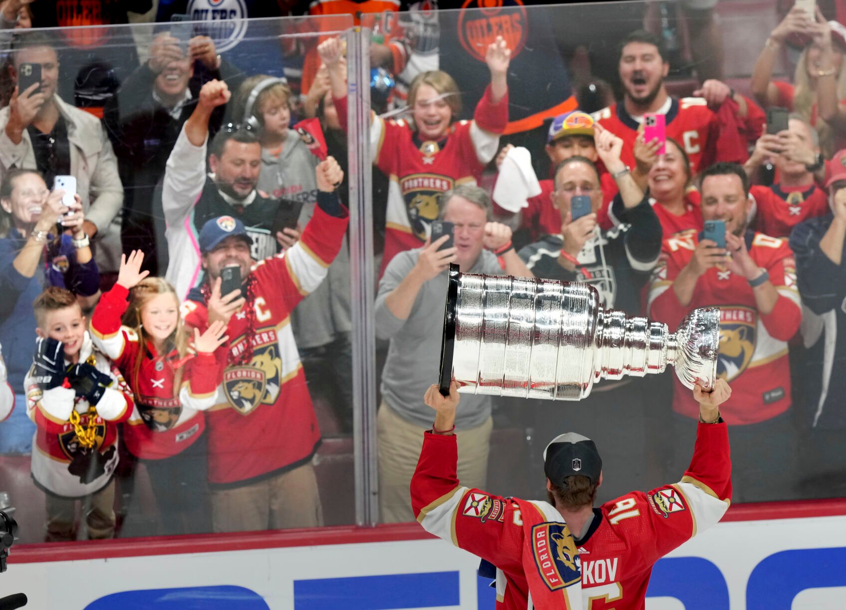 <p>Florida Panthers forward Aleksander Barkov hoists the Stanley Cup in front of fans after defeating the Edmonton Oilers in Game 7 on Monday in Sunrise, Fla.</p>