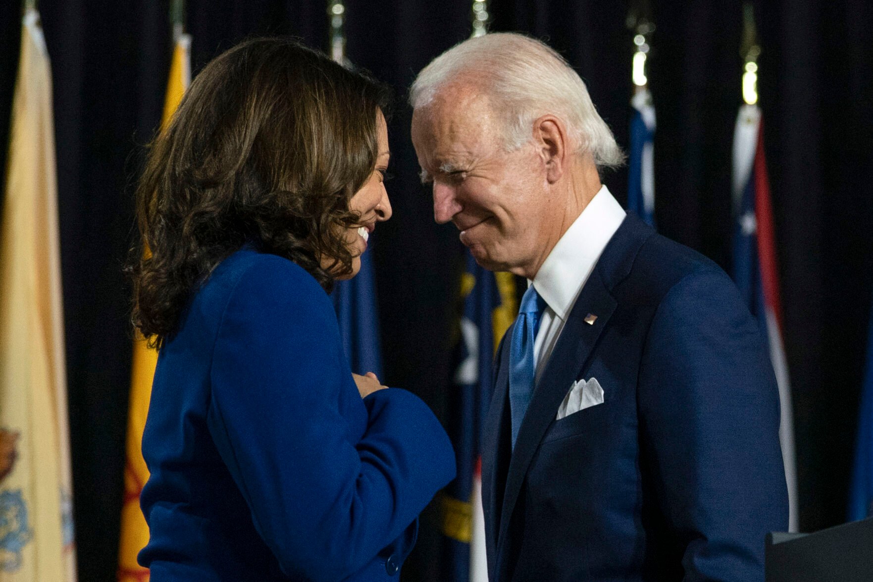 <p>Then-candidate Joe Biden and his running mate Sen. Kamala Harris, D-Calif., pass each other Aug. 12, 2020, as Harris moves to the podium to speak during a campaign event in Wilmington, Del.</p>