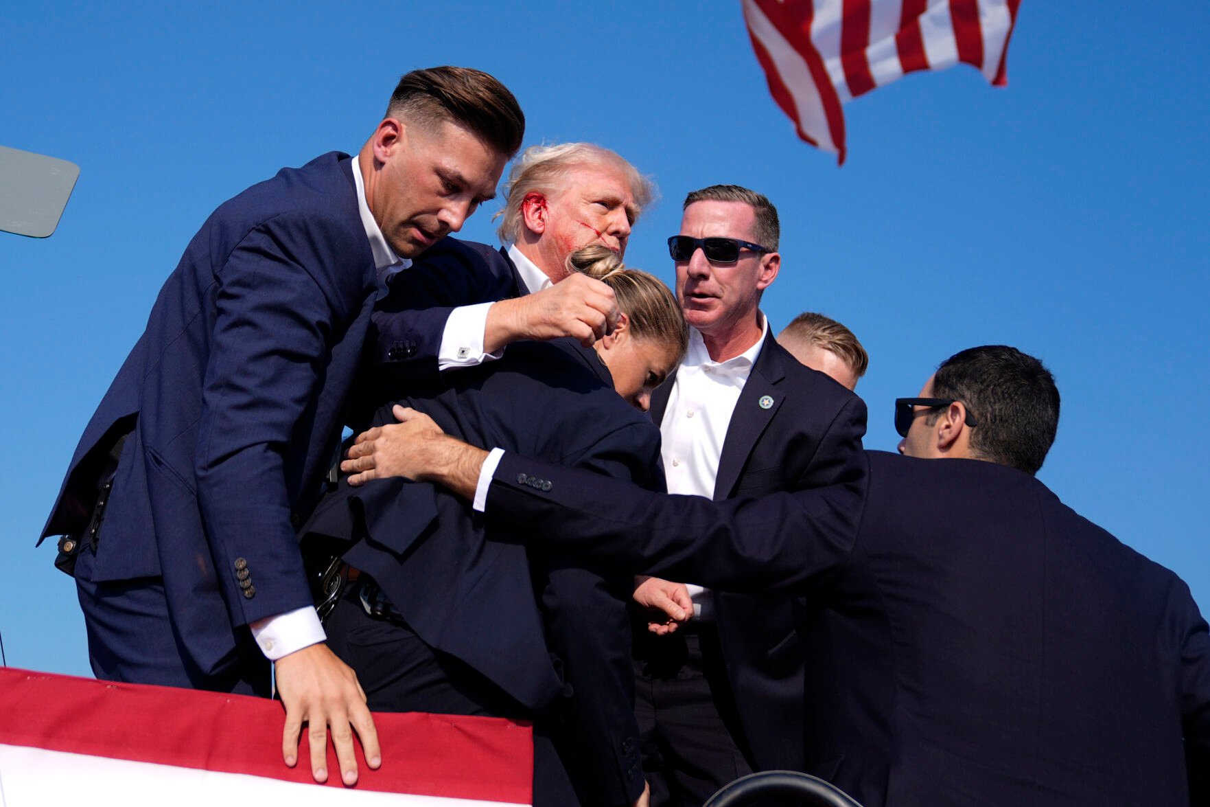 <p>Republican presidential candidate former President Donald Trump is surrounded by U.S. Secret Service agents at a campaign rally after a shooting Saturday in Butler, Pa.</p>