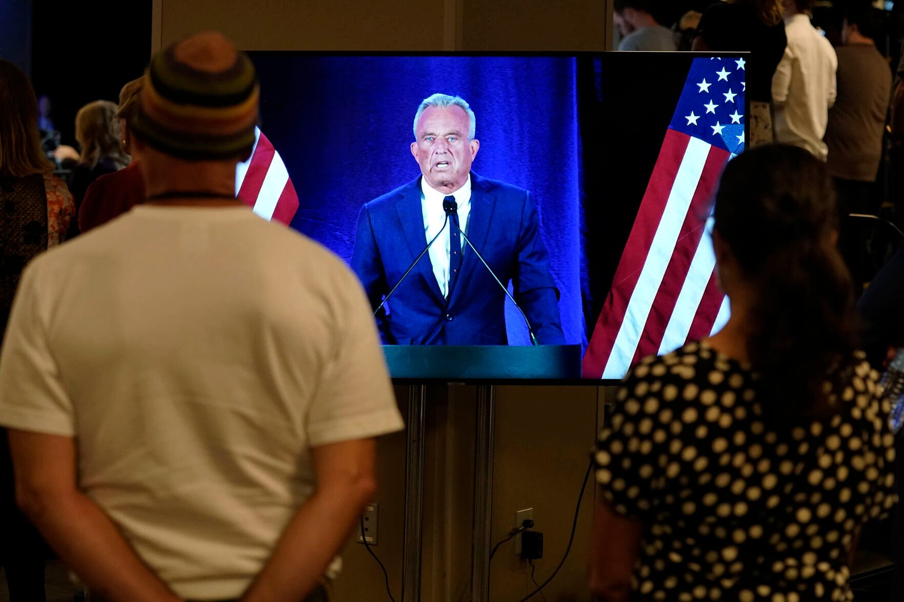 <p>People watch on a monitor Friday as independent presidential candidate Robert F. Kennedy Jr. announces he is suspending his presidential campaign at a news conference in Phoenix.</p>