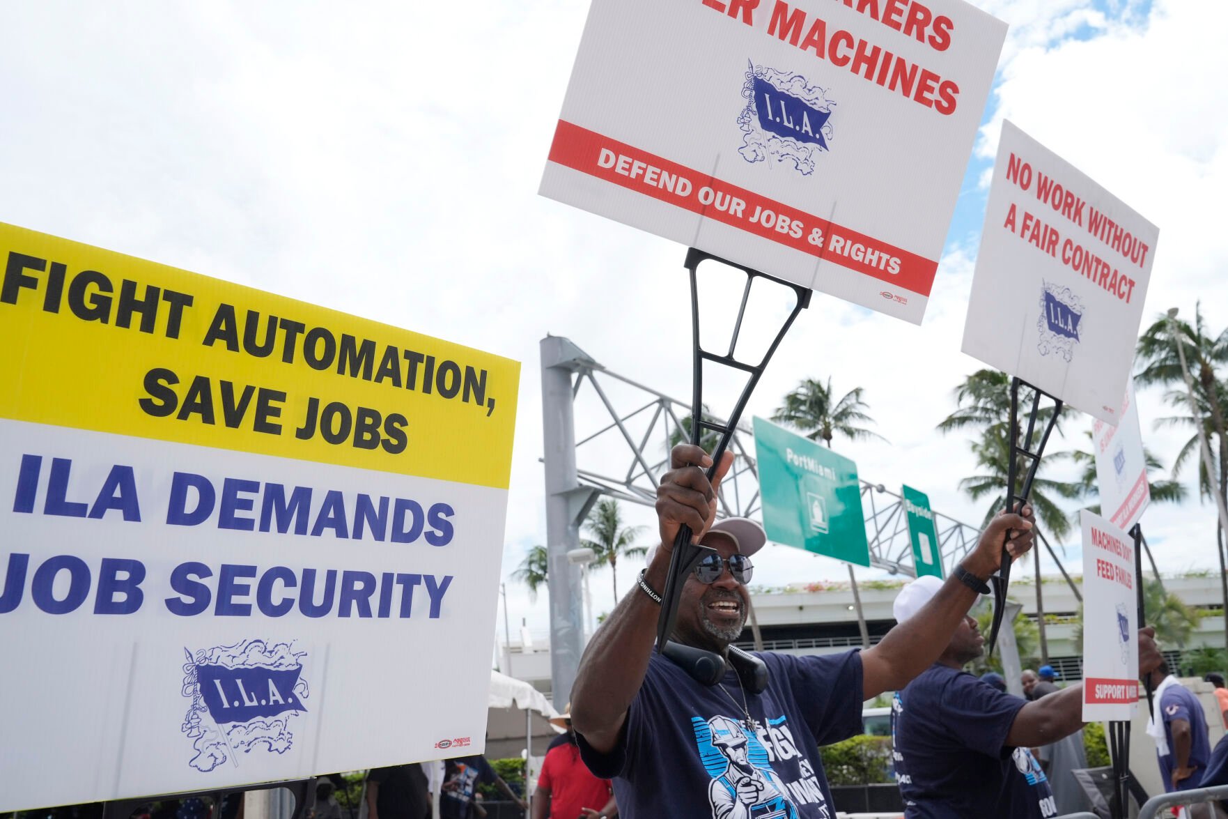 <p>Dockworkers from Port Miami display signs at a picket line Thursday in Miami.</p>