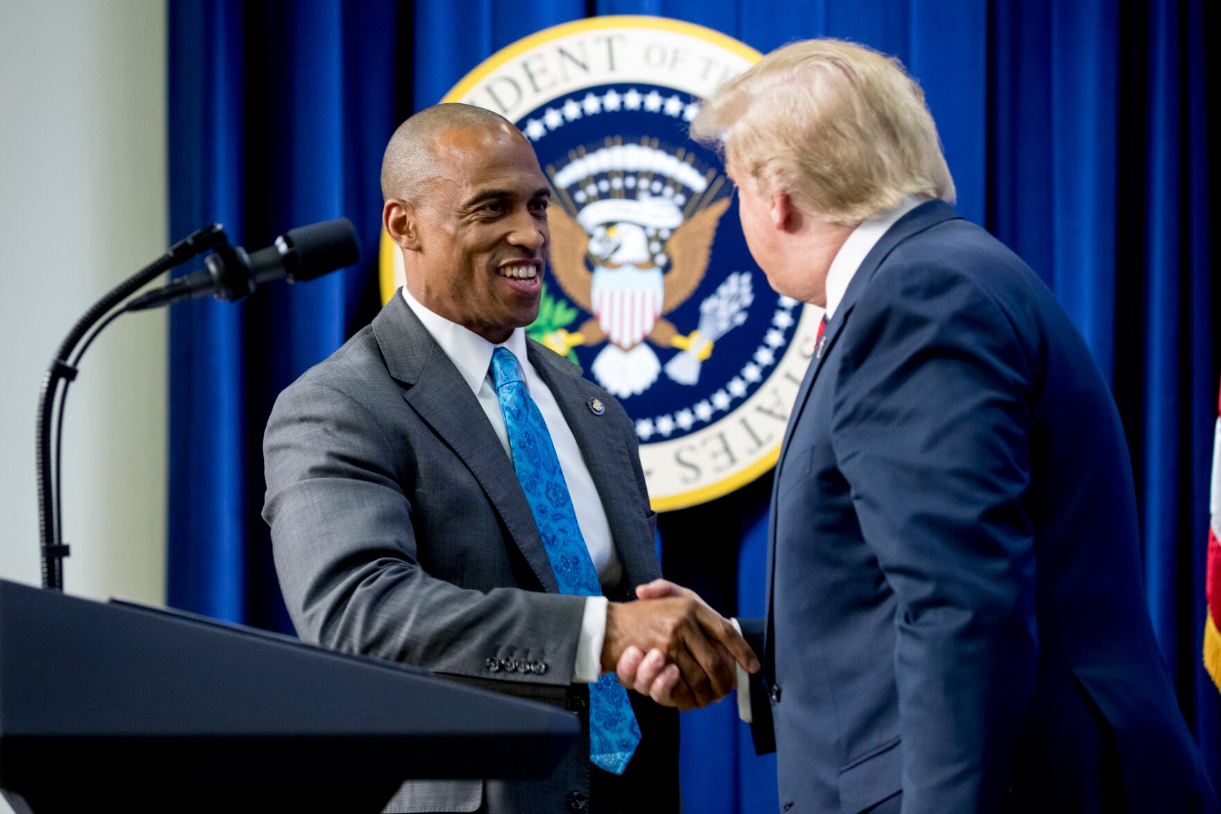 <p>Scott Turner, then-executive director of the White House Opportunity and Revitalization Council, left, is welcomed on stage April 17, 2019, by then-President Donald Trump during an Opportunity Zone conference in the Eisenhower Executive Office Building of the White House complex in Washington.</p>