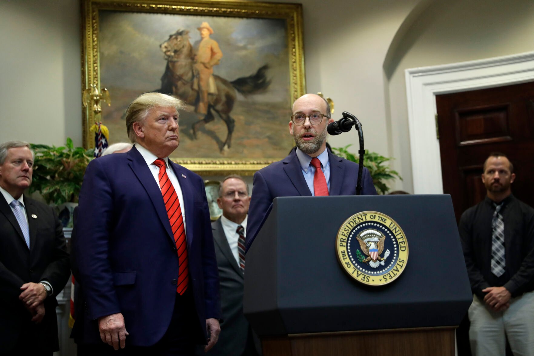 <p>President Donald Trump, left, listens as acting director of the Office of Management and Budget Russel Vought speaks Oct. 9, 2019, during an event on "transparency in Federal guidance and enforcement" in the Roosevelt Room of the White House  in Washington.</p>