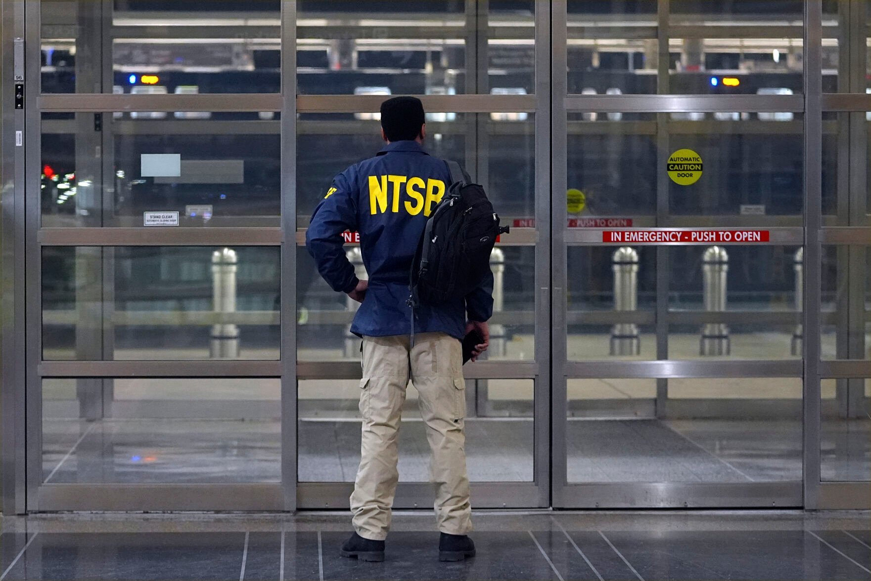 <p>A member of the National Transportation Safety Board stands by a door Wednesday night at Ronald Reagan Washington National Airport in Arlington, Va.</p>