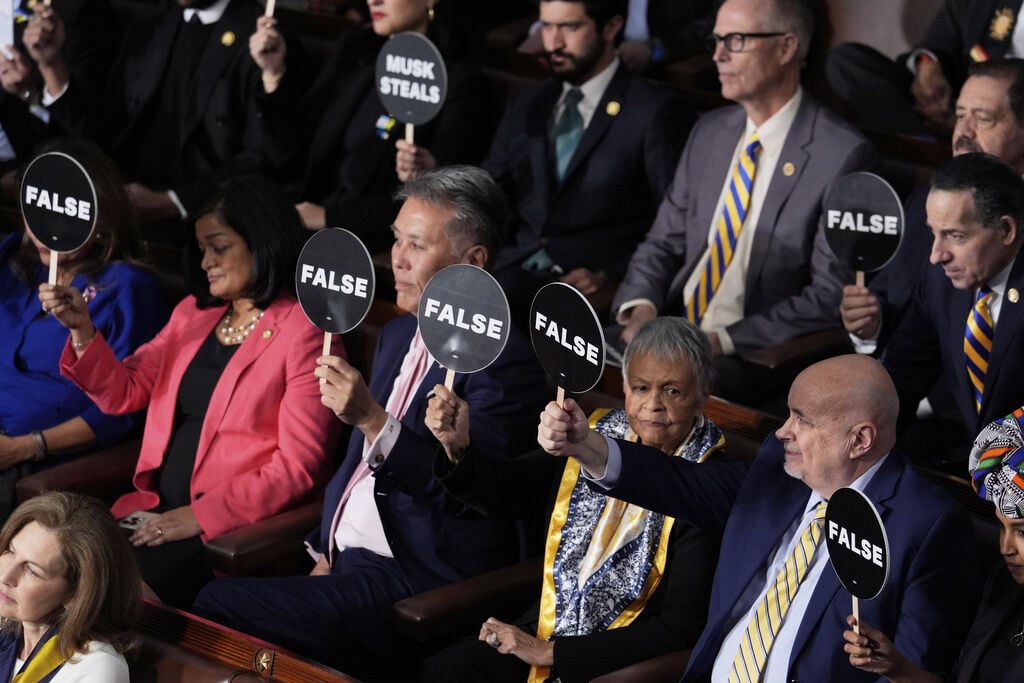 <p>Members of Congress hold up signs as President Donald Trump addresses a joint session of Congress at the Capitol in Washington, Tuesday, March 4, 2025. (AP Photo/J. Scott Applewhite)</p>