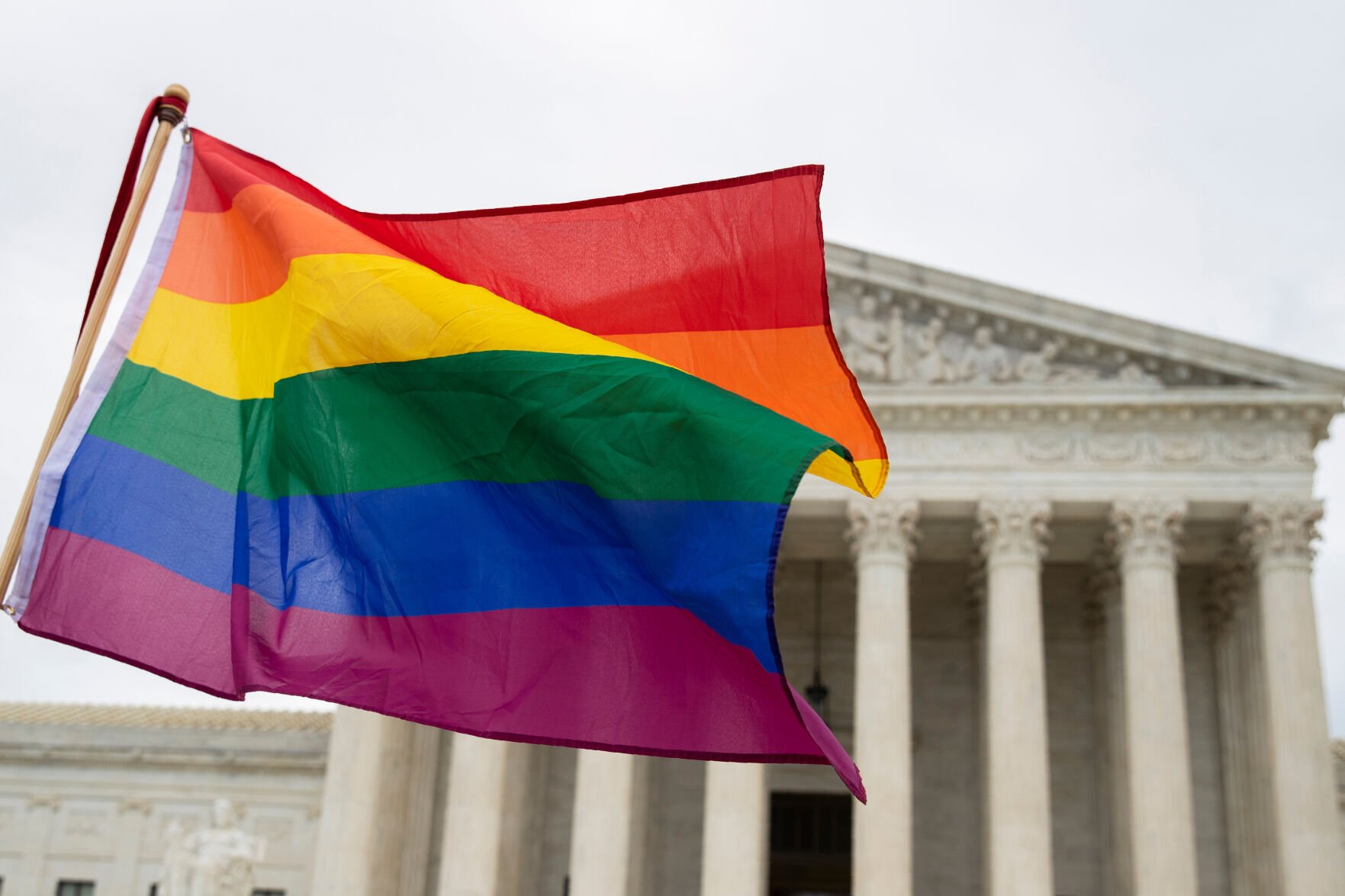 <p>Supporters of LGBTQ rights wave a rainbow flag in front of the U.S. Supreme Court, Oct. 8, 2019, in Washington.</p>