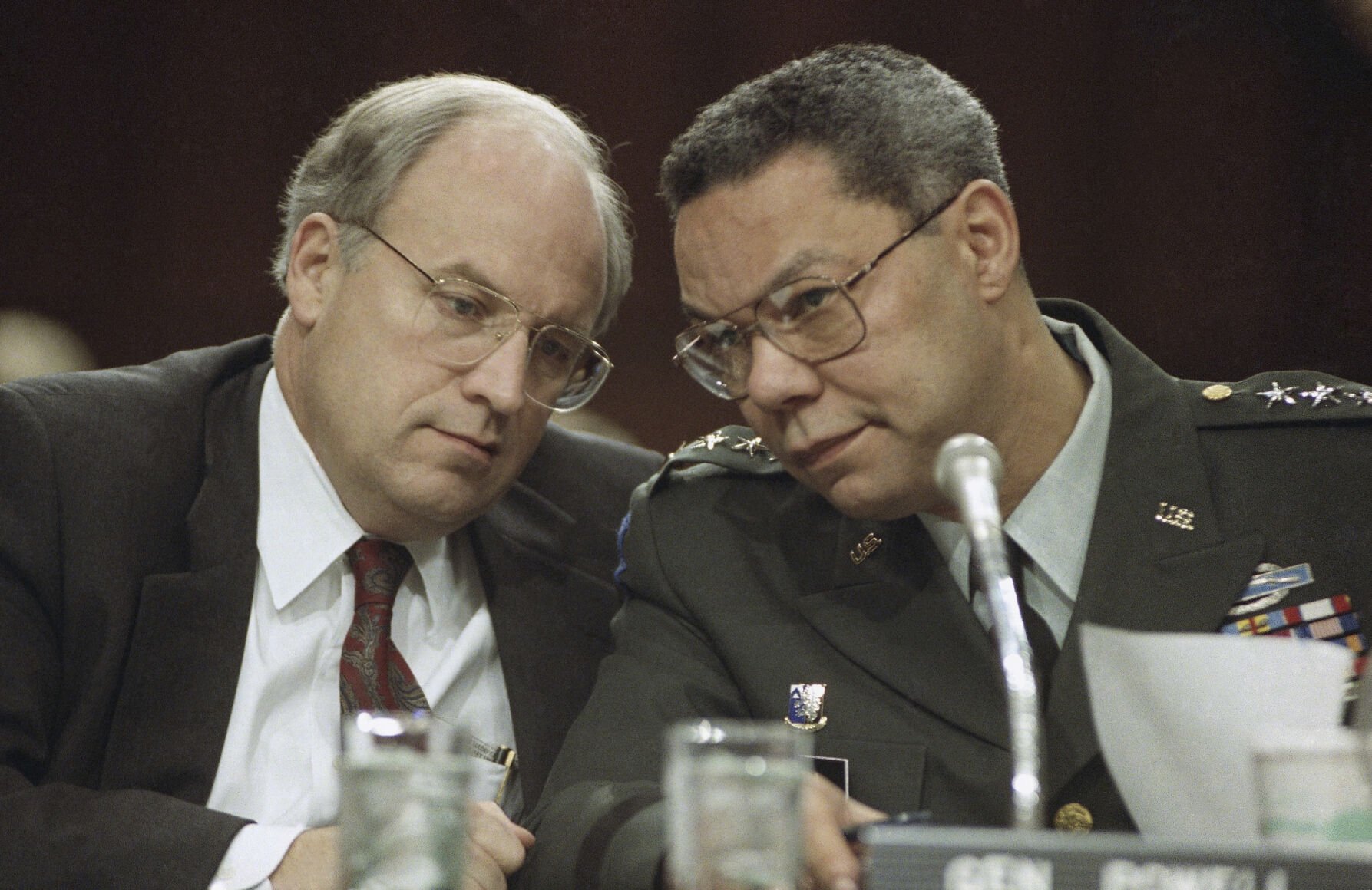 <p>Secretary of Defense Dick Cheney, left, and Chairman of the Joint Chiefs, Gen. Colin Powell, huddle prior to testifying before the Senate Armed Services Committee, Feb. 21, 1991 on Capitol Hill in Washington.</p>