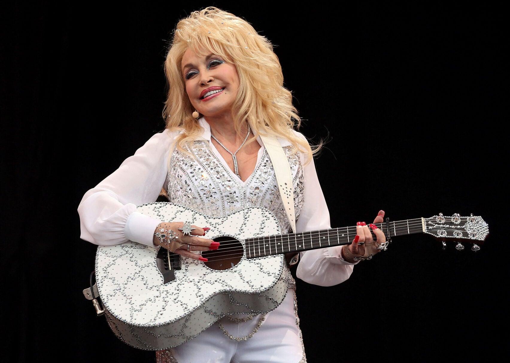 <p>American country music star Dolly Parton performs June 29, 2014, on the Pyramid Stage at Worthy Farm in Somerset, during the Glastonbury Festival.</p>