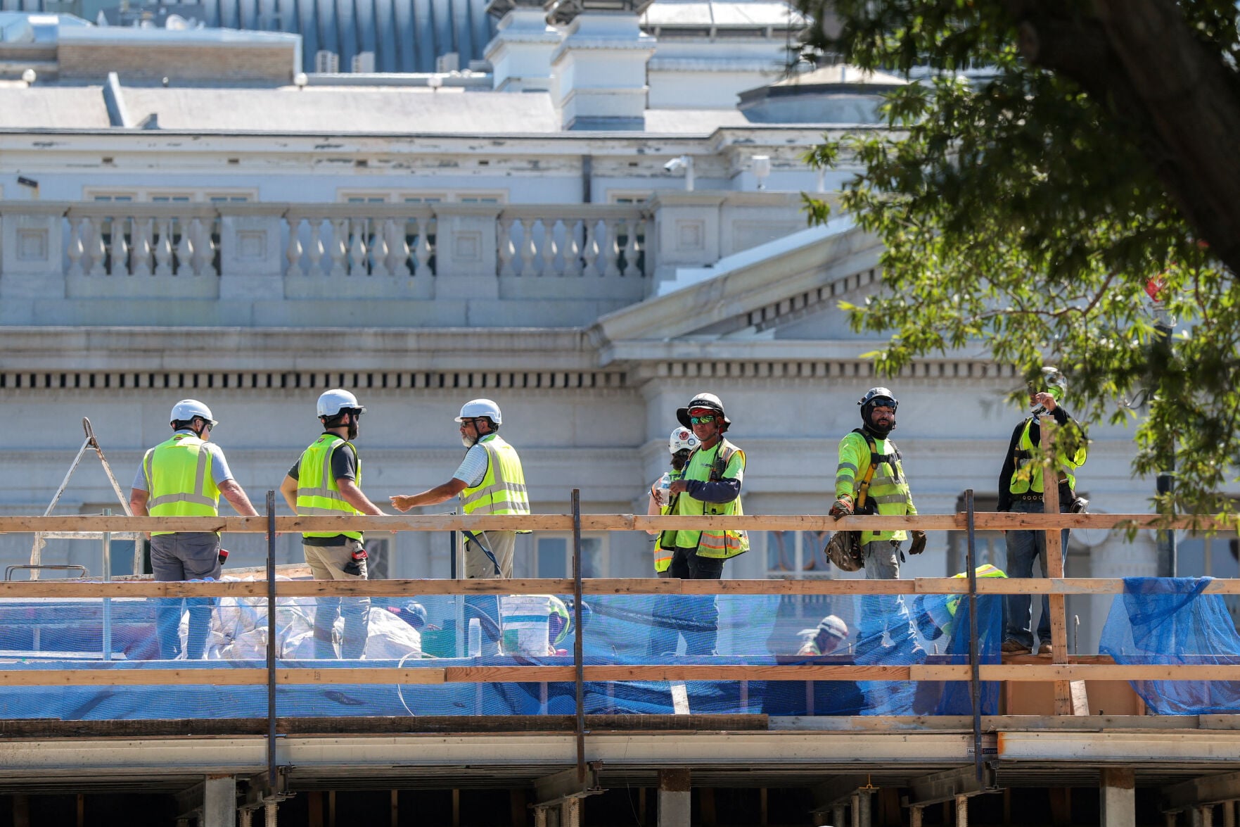<p>Construction workers stand Wednesday at the site of the planned ballroom, where the White House’s East Wing once stood, in Washington.</p>