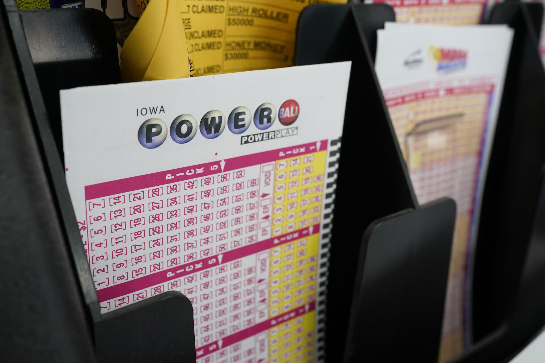 <p>FILE - In this Jan. 12, 2021 file photo, blank forms for the Powerball lottery sit in a bin at a local grocery store, in Des Moines, Iowa. The giant Powerball jackpot has grown even bigger, with officials raising the estimated payout ahead of Saturday, Oct. 2, drawing.(AP Photo/Charlie Neibergall)</p>